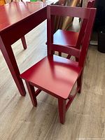 Side view of red child's chair next to table
