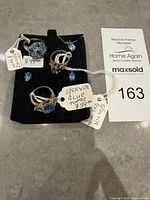 All six sterling silver blue topaz pieces displayed on black pad