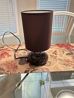 Entire lamp on glass table showing base, shade, cord