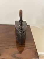 Front perspective of the iron showing wooden handle and pointed sole