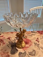 Full view of compote showing cut glass bowl and gold-tone cherub pedestal