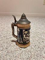 Front view showing hunting figure relief and pewter lid