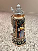 full view of stein front showing Bavarian couple and pewter lid