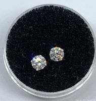 Pair of round diamond stud earrings in display case