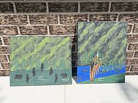Both canvases against brick wall showing relative size and subjects