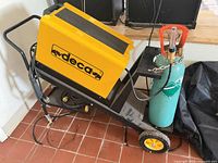 Left side view of Deca MIG welder on cart, cables visible