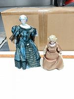 Front view of both porcelain dolls standing