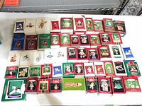 Overview of 50 Hallmark Keepsake ornament boxes on table