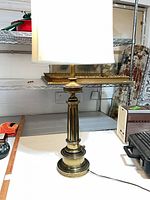 Full view of brass table lamp with shade