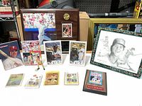Overall lot view showing plaque, framed print, sealed items, jumbo cards, figurine, standard cards and coin