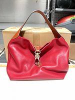 Front view of red leather Dooney & Bourke purse with brown handle