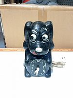 Front view of black dog novelty clock with dial