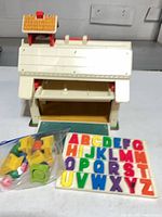 Overall view of Fisher Price schoolhouse with magnetic letters and accessory bag