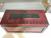 Top view of red wooden toolbox with black lettering and stars