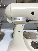 Side view of cream KitchenAid Hobart mixer showing branding and speed selector