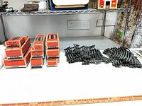Stacked Lionel boxes and grouped track on shelving