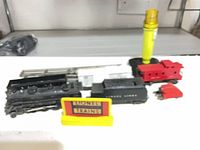 overview of locomotive, tender, cars, rocket, track and sign