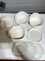 Top view of three bowls, two inserts, one clear lid