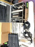 Overview of open hard case showing stacked light heads, cables, stands and accessories
