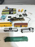 Overview of locomotives, freight cars, curved and turnout tracks, accessories and scenic items