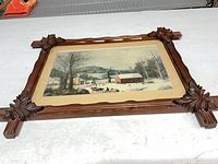Front view of framed print showing image and carved frame