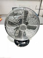 Front view showing chrome grille, blades, plug and base