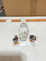 Front view of clear faceted penguin with two smaller birds