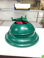 Full view of green Swivel Straight Plus tree stand with red collar and locking levers
