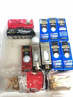 Sleeves of Titleist and other brand golf balls, wooden tees in bags