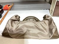 Top view of beige nylon duffle bag showing handles and overall material