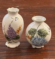 Pair of Princess House porcelain mini bud vases with floral designs on wooden surface
