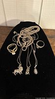 Group shot of entire lot showing two rings and multiple necklaces with pendants