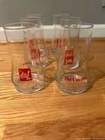 Six clear 7Up Uncola glasses shown upright