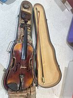 Violin inside open case with bow and accessories