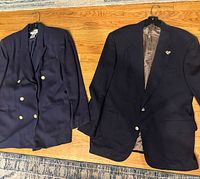 Both navy blazers laid flat showing fronts and buttons