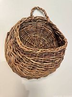 Front view of wicker wall pocket basket showing overall form and weave