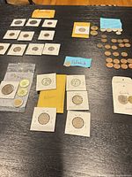 Wide view showing grouped coin holders and loose coins labeled by country