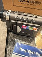 Side view of Microtek Take-It MV500 showing controls and 12x zoom marking beside original box