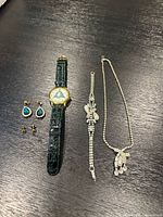 Group shot showing wristwatch, two earring pairs, bracelet and necklace