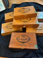 Stack of eight Carlos Toraño Reserva Selecta wooden cigar boxes showing brand graphics and two distinct sizes