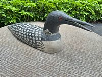 Front three-quarter view of carved wooden loon showing paint pattern and signature area