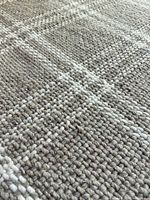Close-up of rug weave showing wool blend texture and plaid pattern
