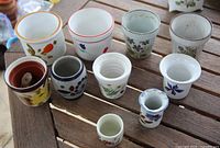 Front view of all ten ceramic pots on table