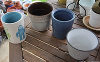 Four ceramic pots on wooden table