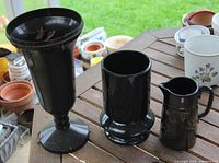 Front view of three black vases on table