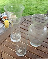 Three clear glass vases on wooden surface