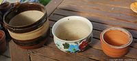 Three planter pots side by side showing exterior colors and relative sizes