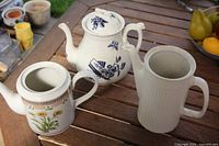 Three ceramic pitchers on wooden table