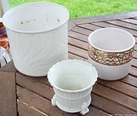 Three planters upright on table showing designs