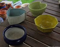 Top view of four glazed ceramic planters showing shapes and colours